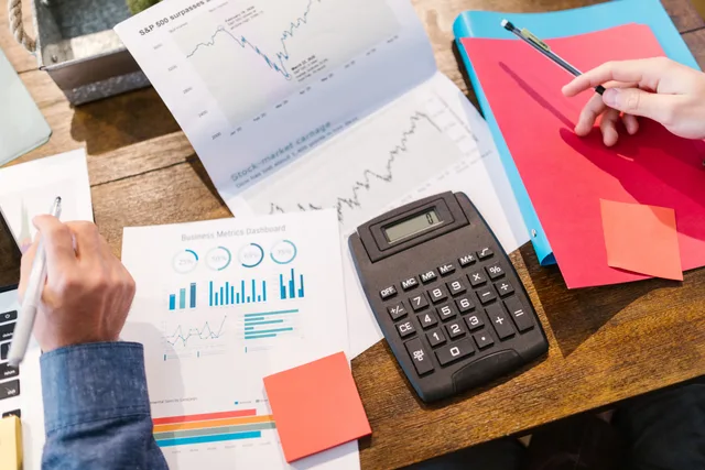 Financial analysis and planning tools with graphs and calculator on a table. Customer Retention Software Pricing UK: VAT and Add-On Costs