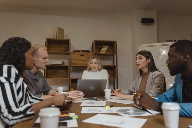 Group of professionals collaborating in a modern office setting during a strategic meeting. How to size England's customer success software market with illustrative inputs