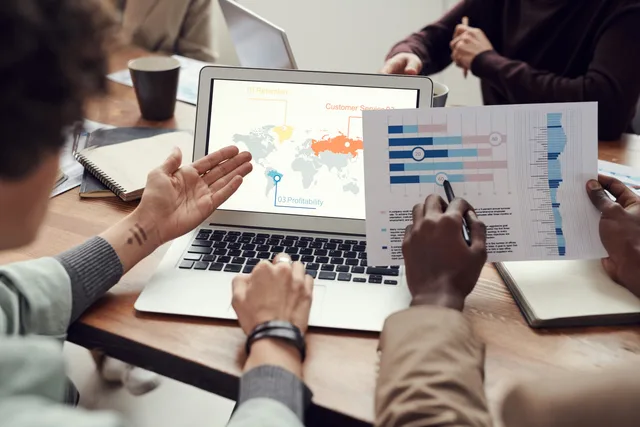 Professional team discussing analytics and brainstorming ideas in a meeting room. Choosing customer success software key metrics without vanity numbers