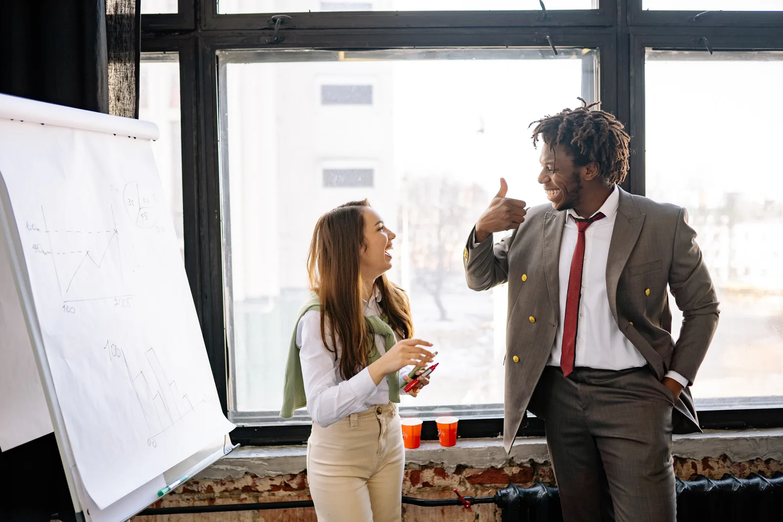 Two business professionals share a moment of success during a meeting, showcasing teamwork and collaboration.