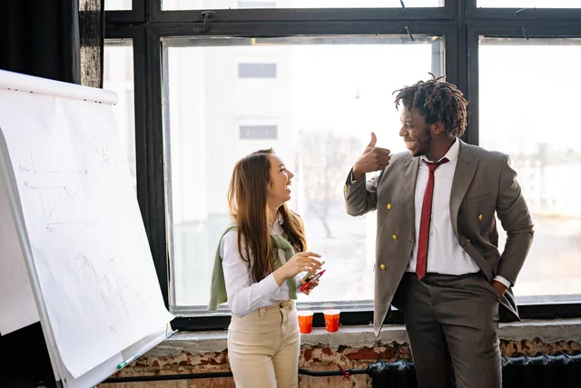 Two business professionals share a moment of success during a meeting, showcasing teamwork and collaboration. Customer success software: seven measurement pitfalls