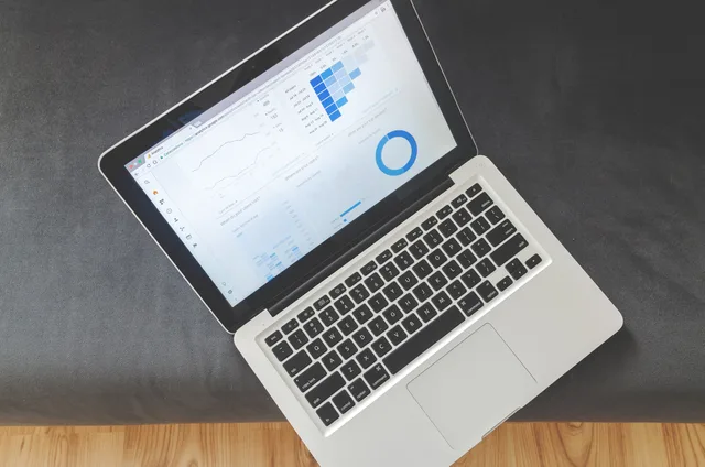 Overhead view of a laptop showing data visualizations and charts on its screen. When UK teams need customer success software